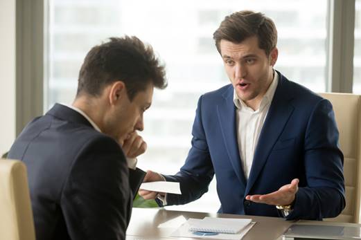 Man talking to stressed coworker